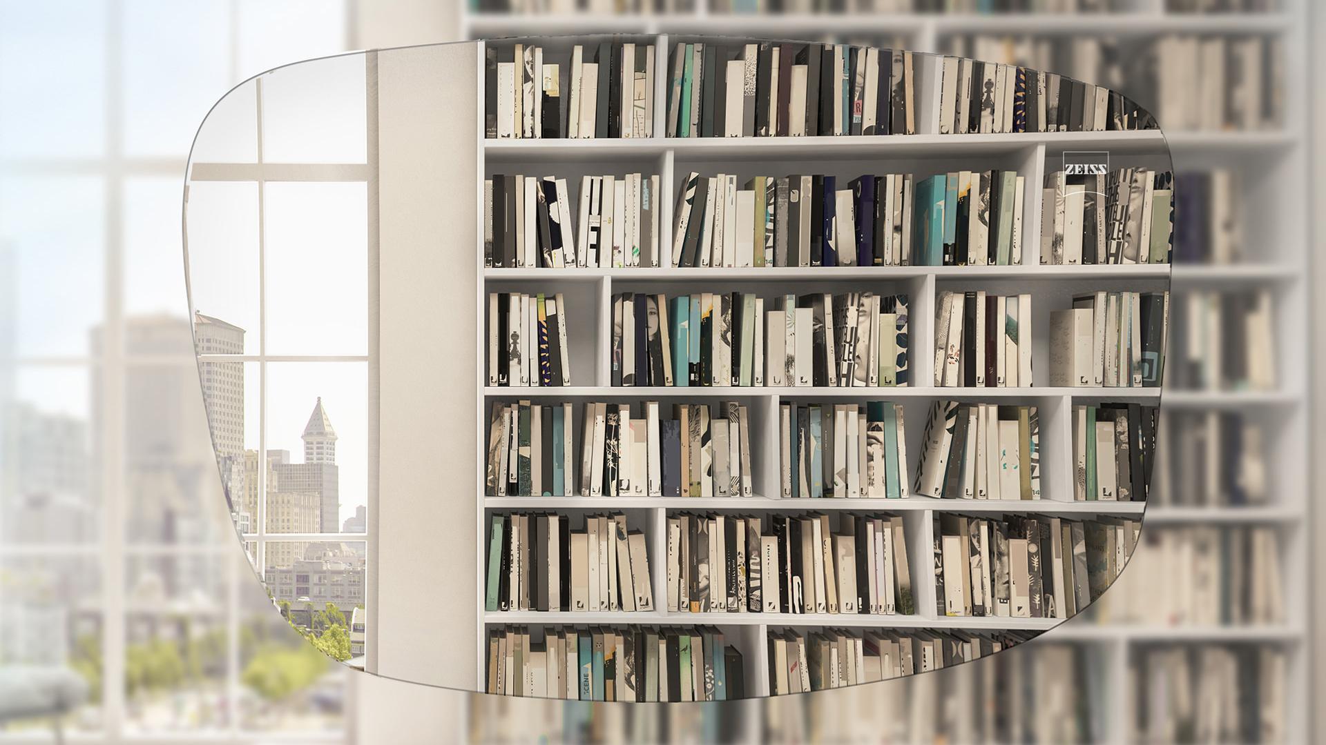 Verzerrter Blick durch das Brillenglas auf ein Bücherregal und Fenster. ZEISS AS Einstärkengläser bieten eine hervorragende Sehqualität. 