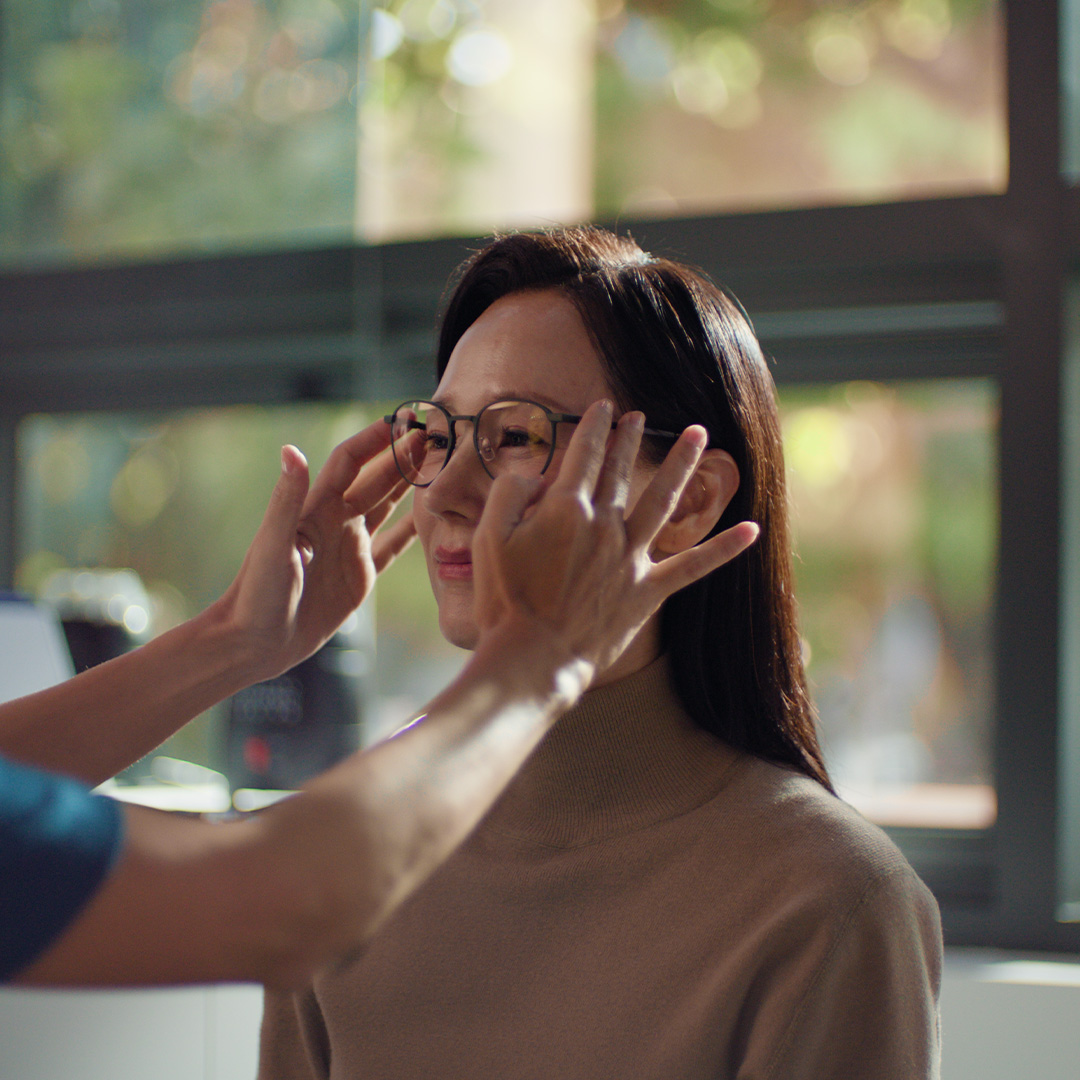 Eine Frau probiert eine Brille an.