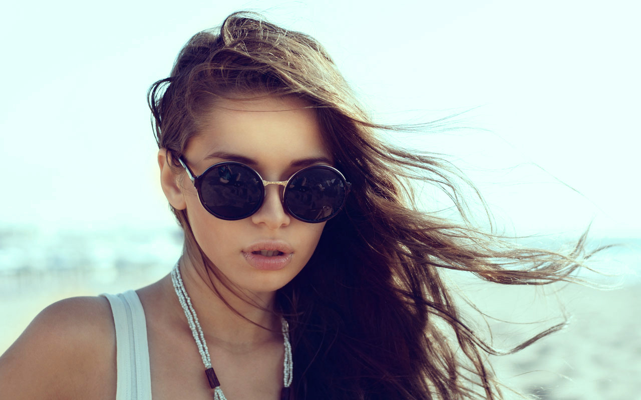 Mädchen mit Sonnenbrille am Strand