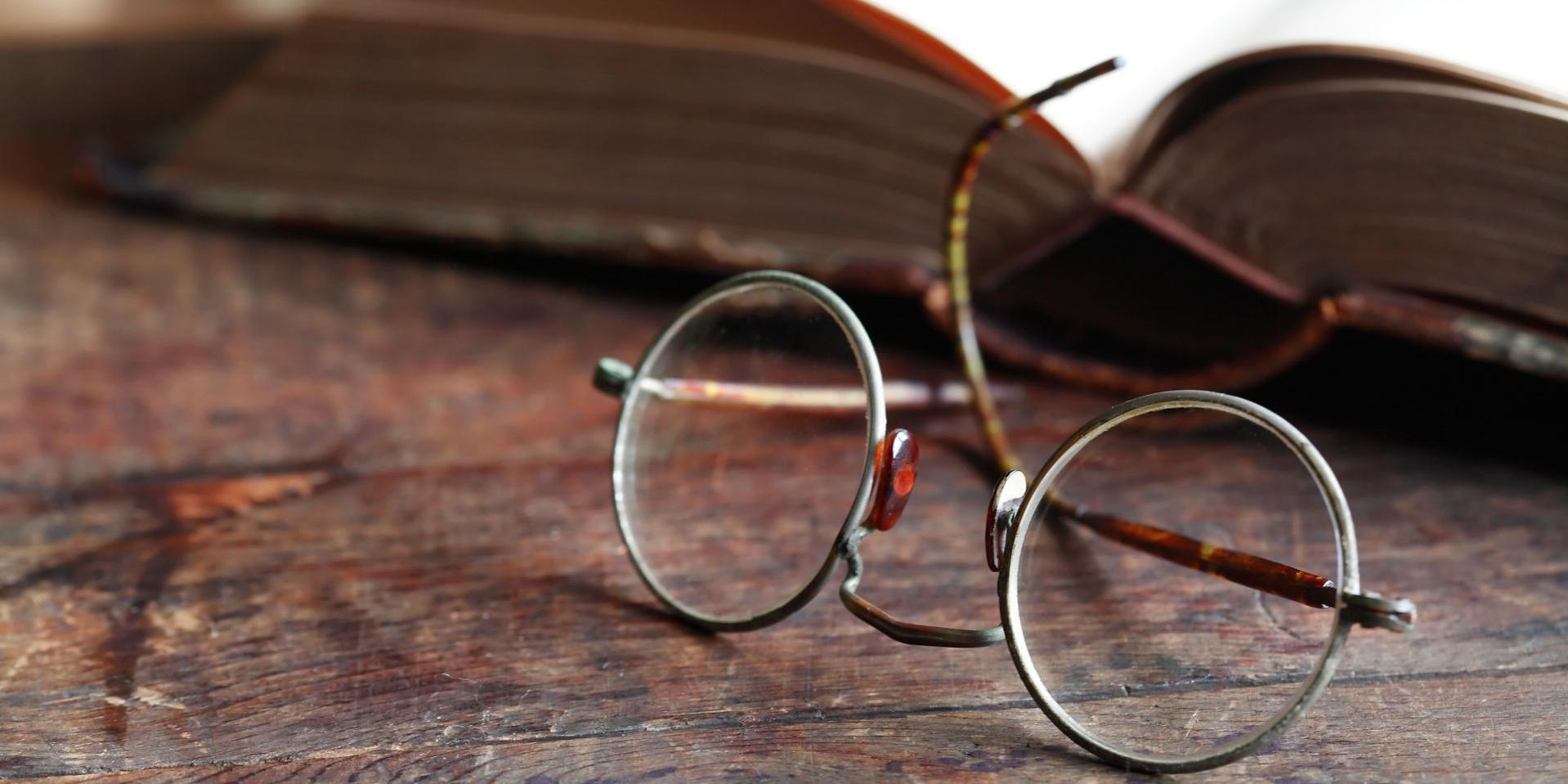 Eine Brille liegt vor einem Buch