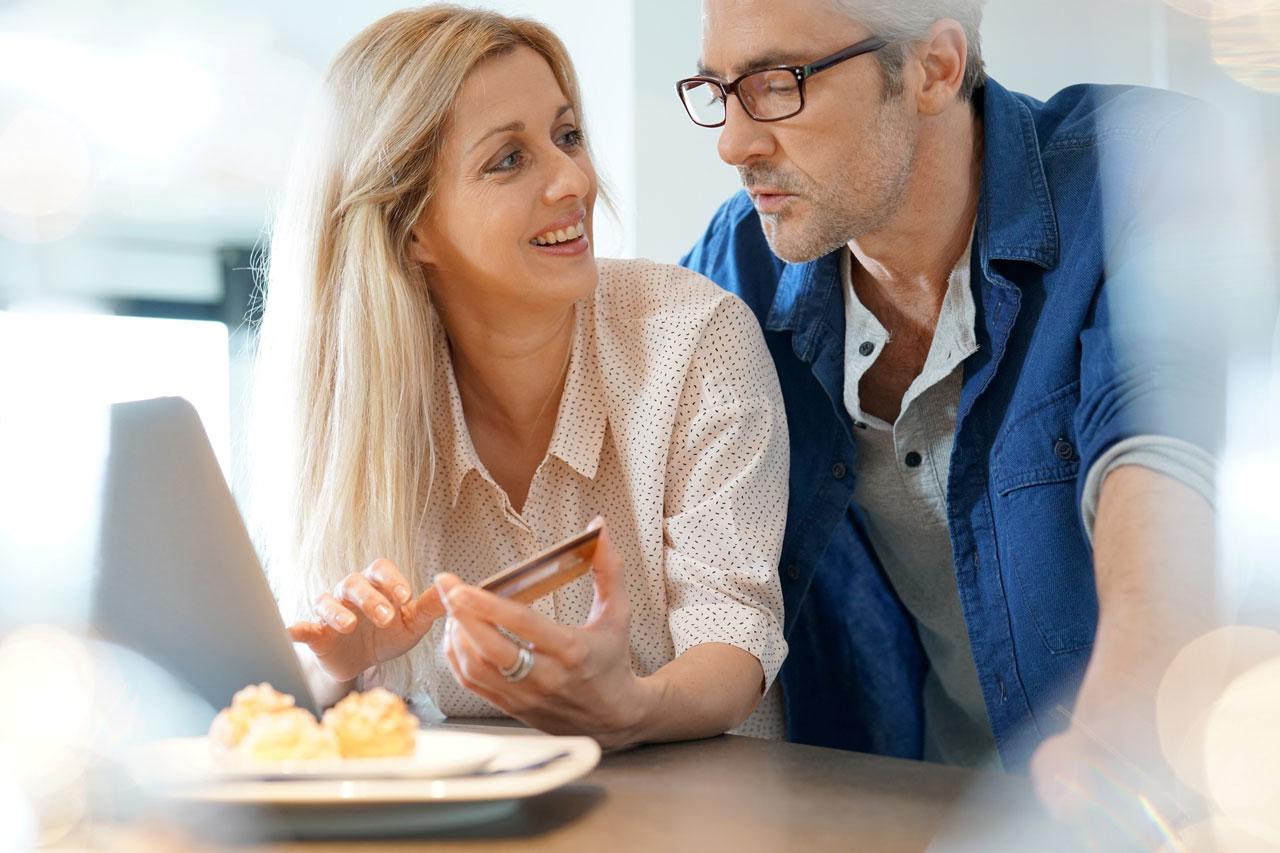 Couple d’âge mur faisant des achats sur internet de chez lui.