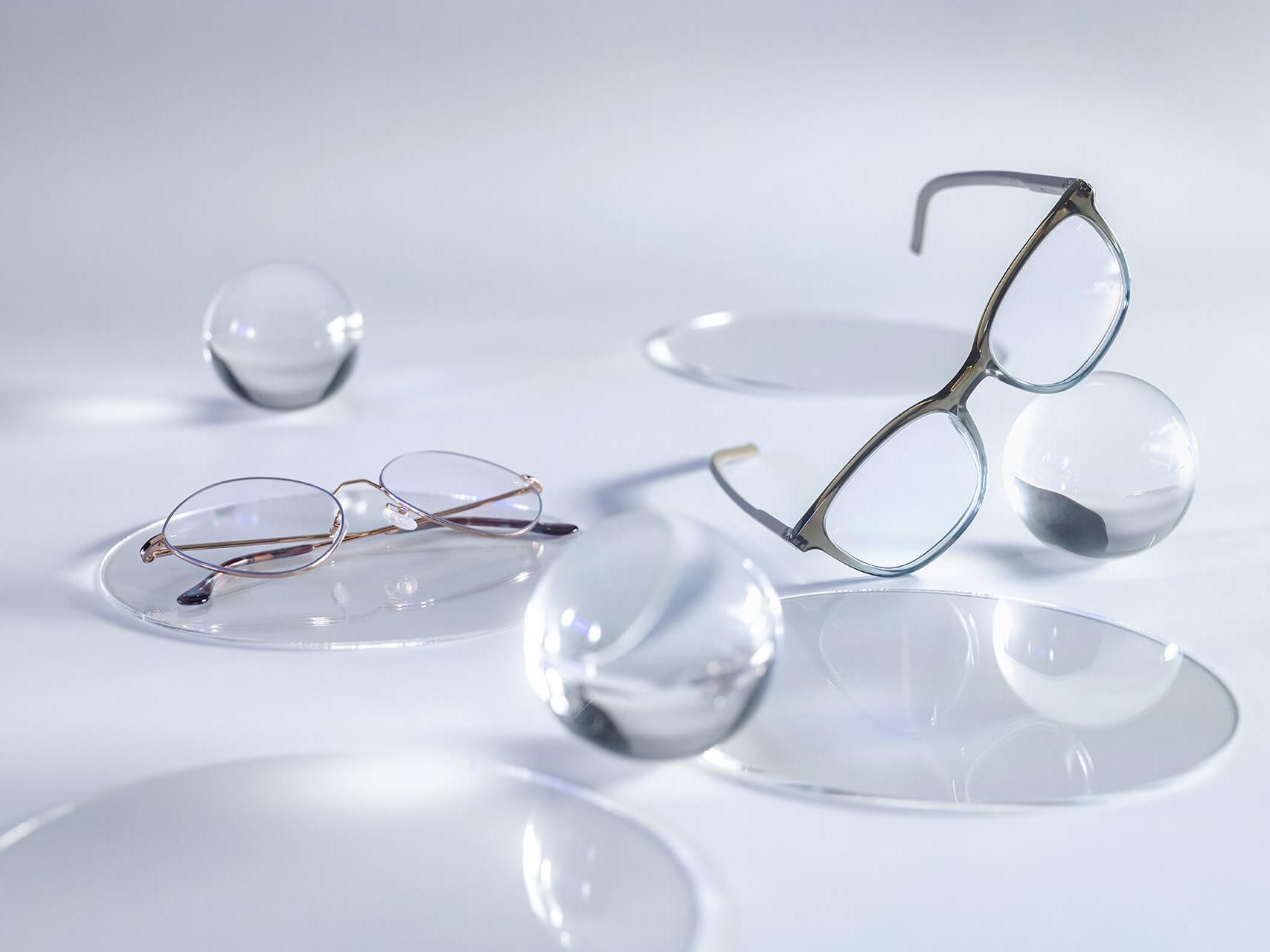 Lunettes dotées de verres ZEISS avec le traitement DuraVision® Silver qui ne présentent aucun reflet par rapport aux sphères de verre qui l’entourent.