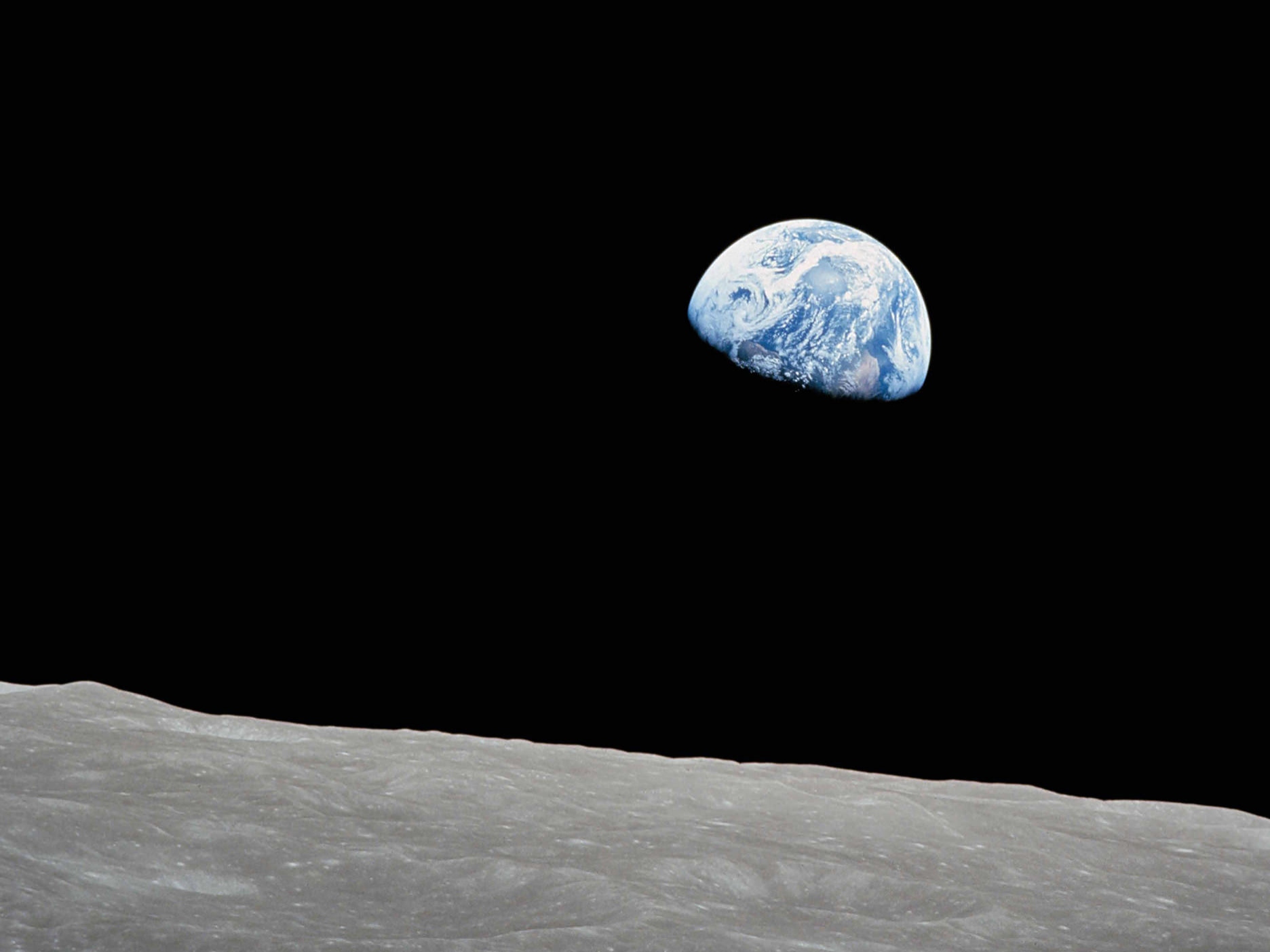 Perspective d’une personne se tenant sur la surface de la lune et regardant vers la terre.