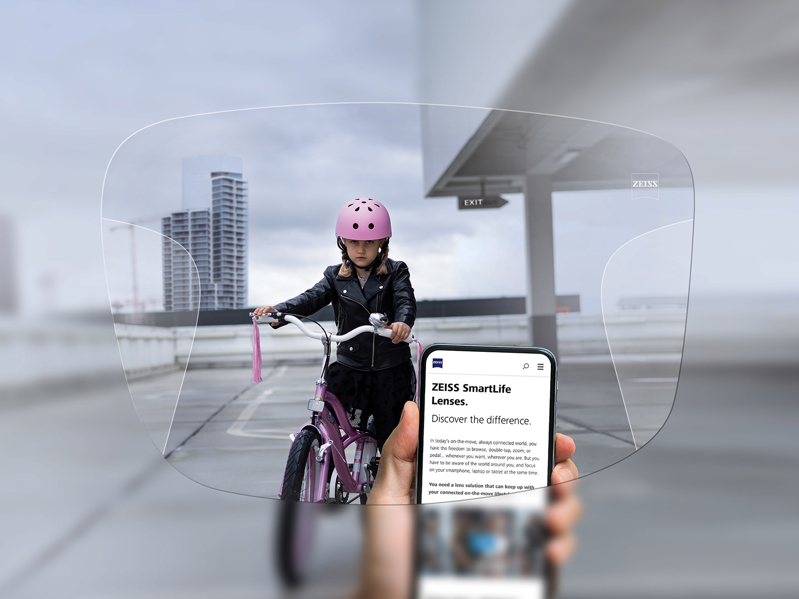 Jemand schaut durch ZEISS SmartLife Gleitsichtgläser aufs Telefon. Im Hintergrund sieht man ein Mädchen mit einem rosa Fahrradhelm auf einem Fahrrad. 