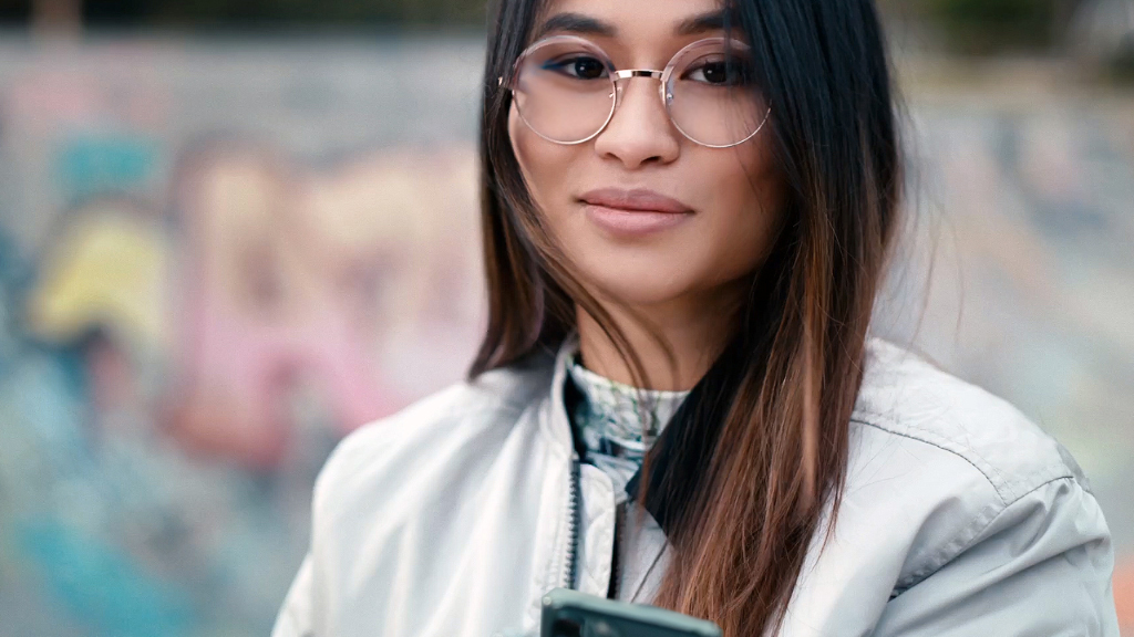 Une jeune femme dans un skatepark portant des verres Single Vision ZEISS SmartLife.